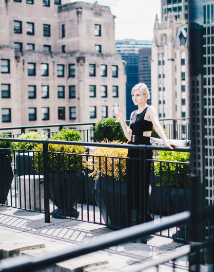 A lady enjoying a drink on The Gwen's rooftop patio in downtown Chicago.